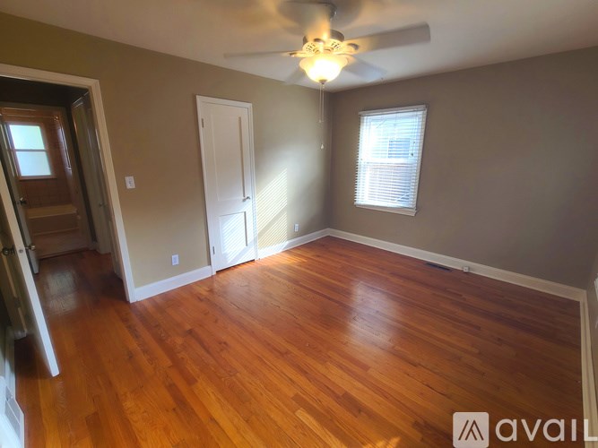 A room with wooden floors and a ceiling fan.