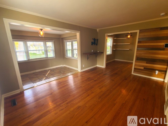 A room with wooden floors and a window with blinds.