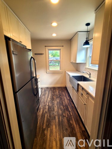 A kitchen with wooden floors and white cabinets.