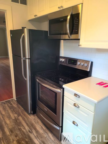 A kitchen with a black fridge, stove, and microwave.