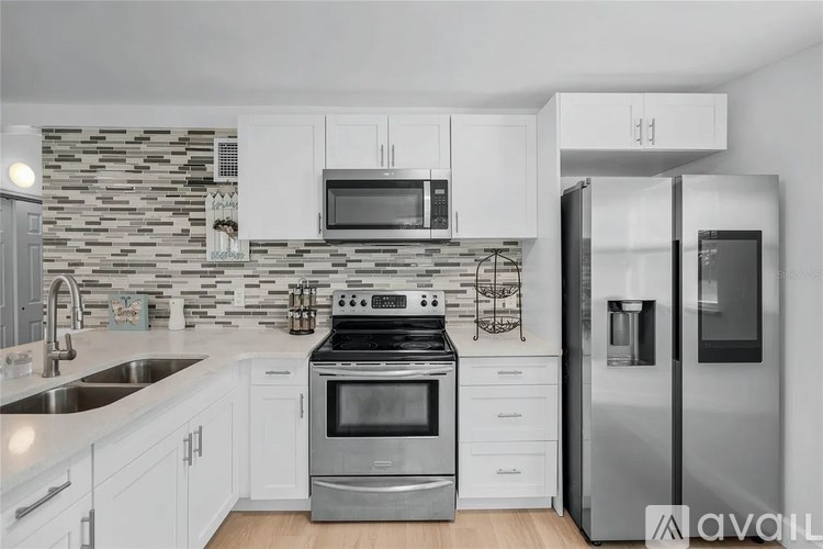 A kitchen with a stove, refrigerator, and microwave.