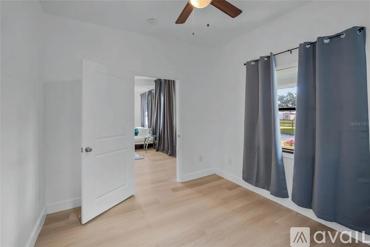 A room with a white door and a ceiling fan.
