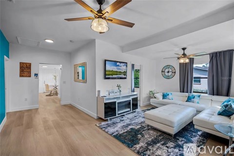 A living room with a white couch and a ceiling fan.