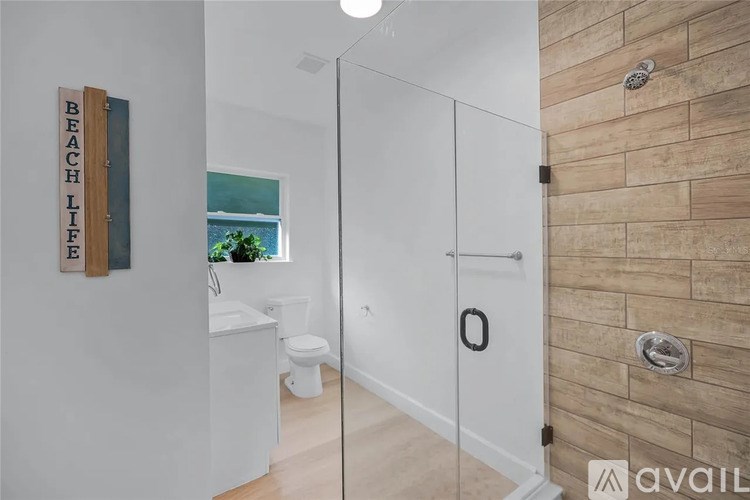 A bathroom with a wooden sign that says "BEACHLIFE" on the wall.
