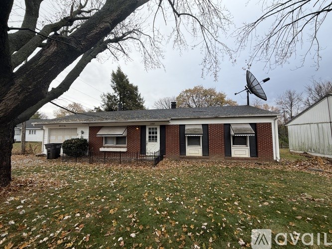 A house with a satellite dish on the roof is surrounded by fallen leaves.