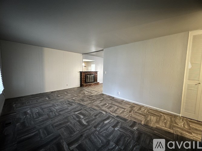 A room with a carpeted floor and a window on the left side.