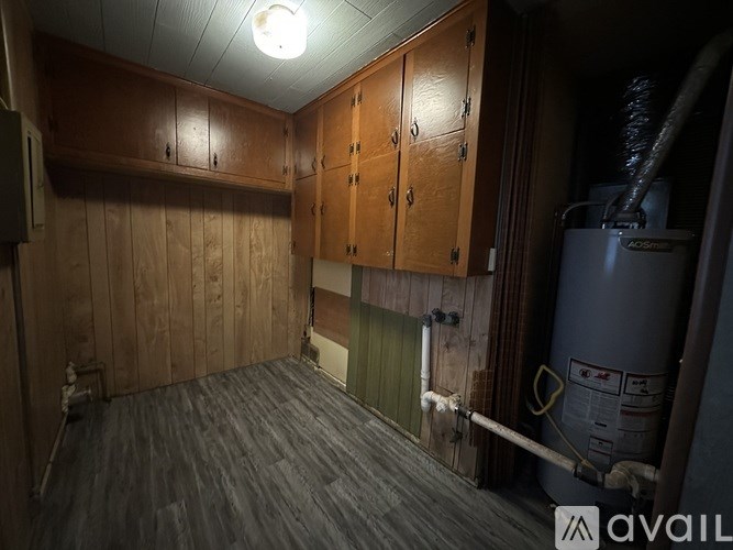 A room with wooden cabinets and a grey floor.