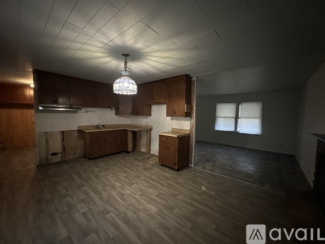 A room with wooden floors and a large window.