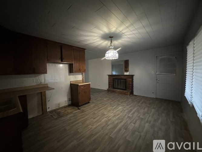 A room with wooden floors and a chandelier hanging from the ceiling.