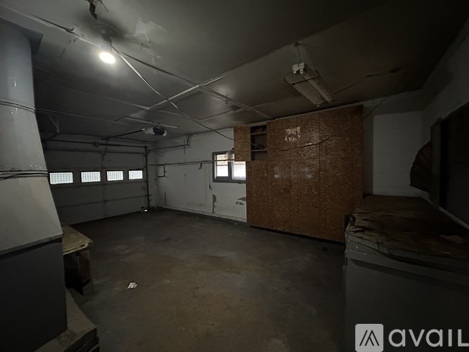 A large, empty room with a brick wall and a window.