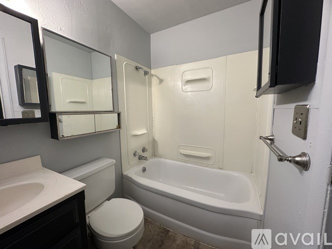 A bathroom with a white toilet, sink, and bathtub.