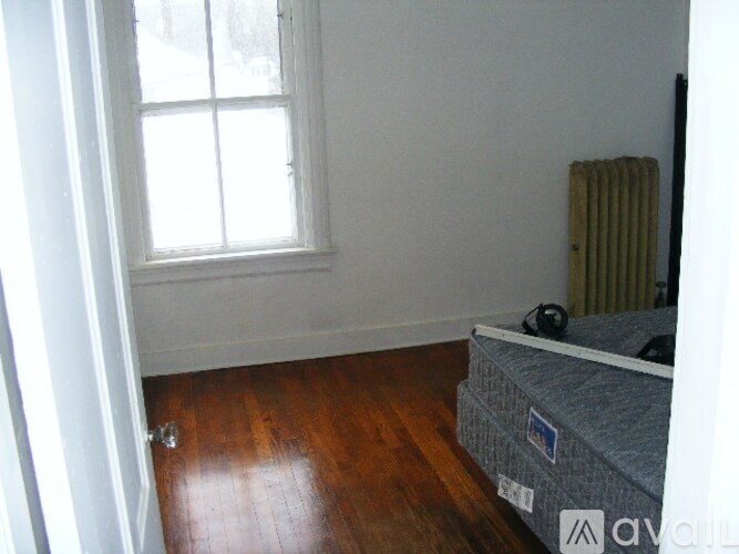 A room with a window and a bed.