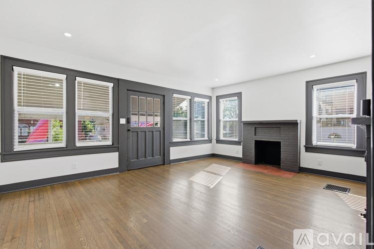 A living room with a fireplace and a large window.