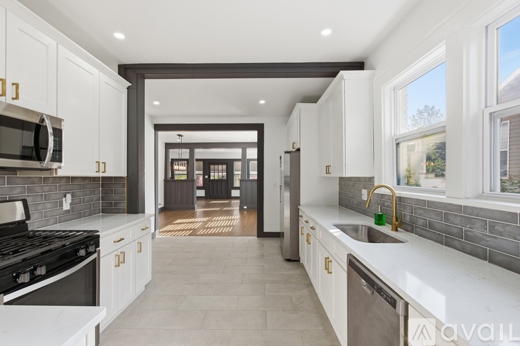 A modern kitchen with white cabinets and a black stove top.