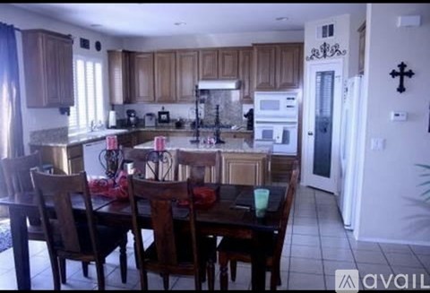 A kitchen with wooden cabinets and a dining table with chairs.