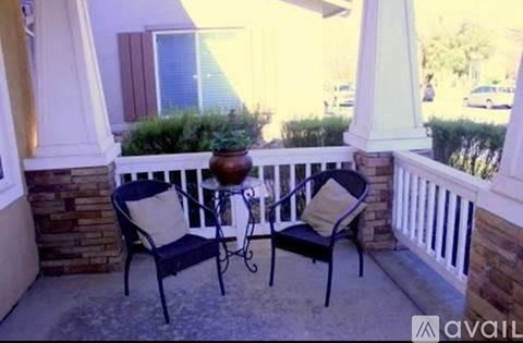 A patio with two chairs and a table.