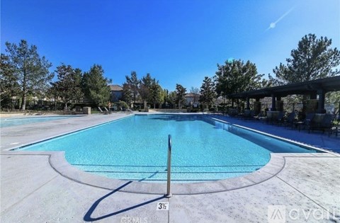 A large outdoor swimming pool with a clear blue sky above.