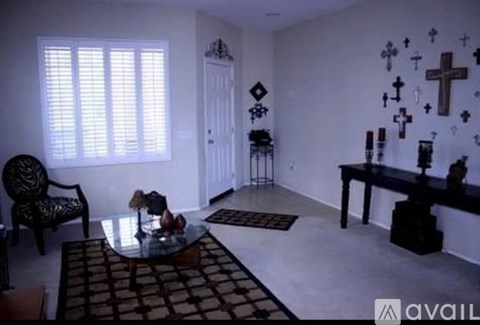 A room with a table, chairs, and crosses on the wall.