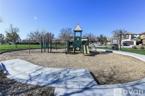 A playground with a green tower structure and a slide.