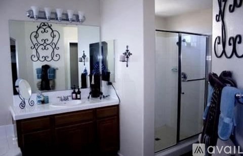 A bathroom with a mirror, sink, and towel rack.