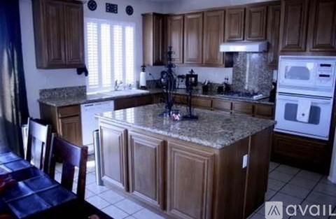 A kitchen with wooden cabinets and a granite countertop.