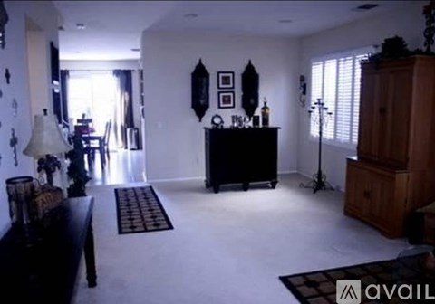 A living room with a black piano and a wooden cabinet.
