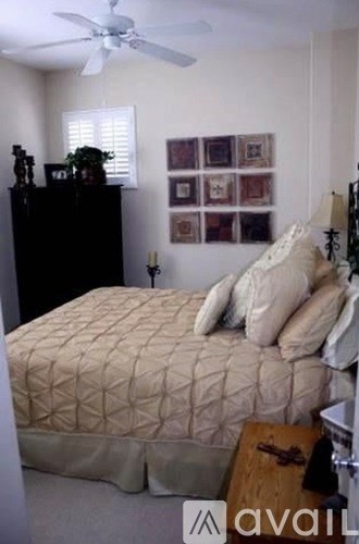 A bedroom with a bed, dresser, and wall art.