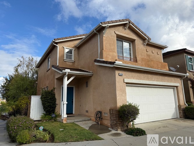 A two-story house with a garage and a blue door.