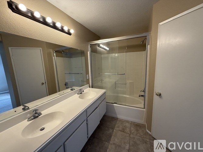 A bathroom with a vanity, a mirror, and a shower.