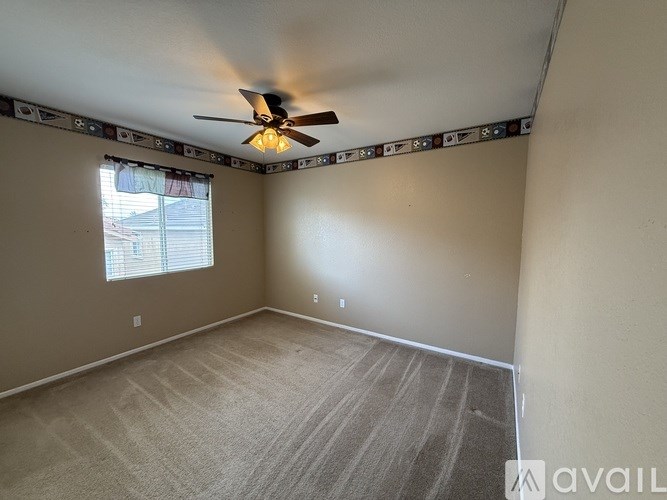 A room with a ceiling fan and carpeted floor.