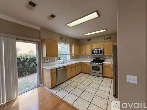 A kitchen with wooden cabinets and a tile floor.