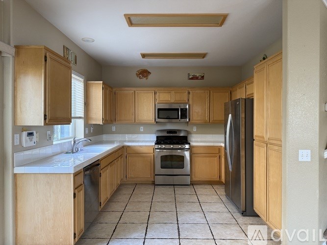 A kitchen with wooden cabinets and a tile floor.