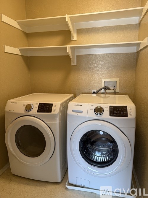 Two front loading washing machines in a laundry room.