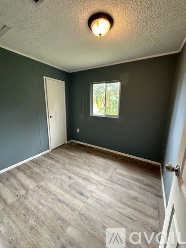 A room with a wooden floor and a window.