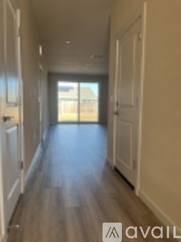 A long hallway with white doors on both sides.