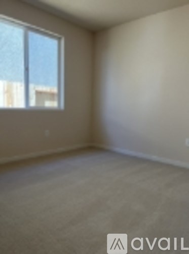 A room with a window and carpeted floor.