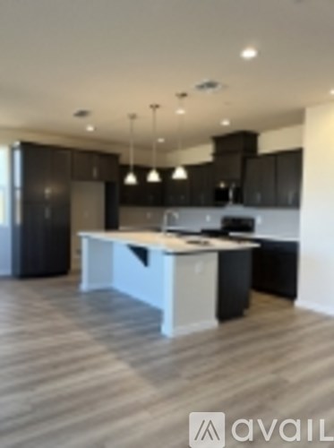 A kitchen with a white island and black cabinets.