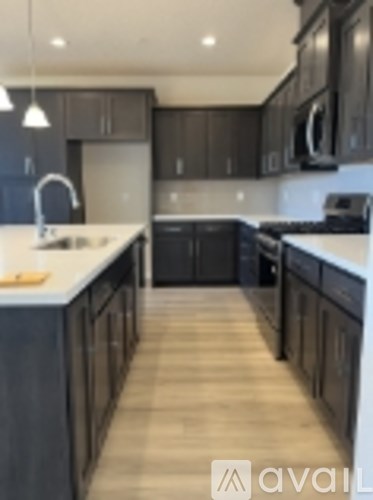 A modern kitchen with dark brown cabinets and a white countertop.