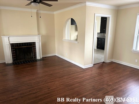 A room with a fireplace and a ceiling fan.
