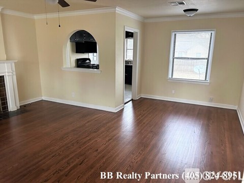A room with a fireplace and wood flooring.