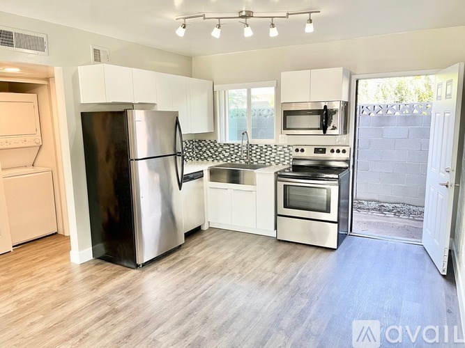 A kitchen with a black fridge, stove, and oven.