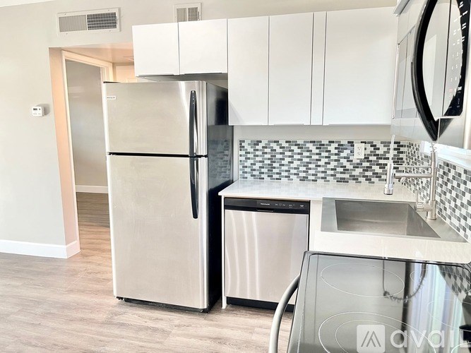 A kitchen with a stainless steel refrigerator and a dishwasher.
