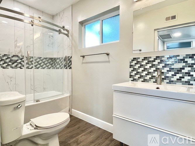 A bathroom with a toilet, sink, and shower.