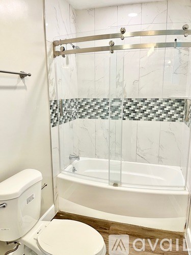 A white toilet sits next to a bathtub in a bathroom.