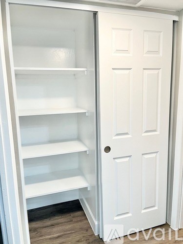 A white refrigerator with its door open in a room.