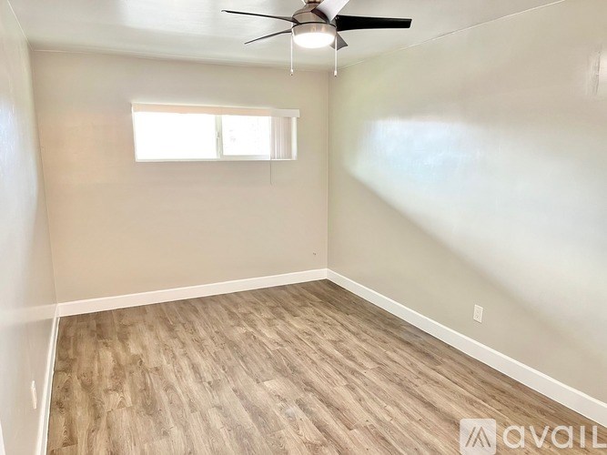 A room with a ceiling fan and a window.
