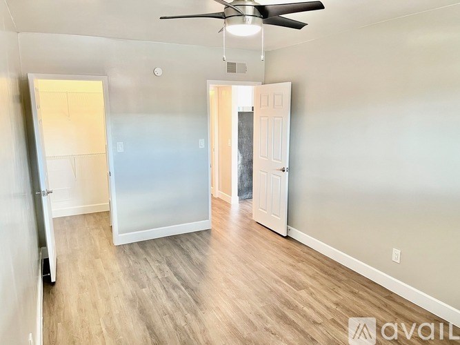 A room with a ceiling fan and two doors.