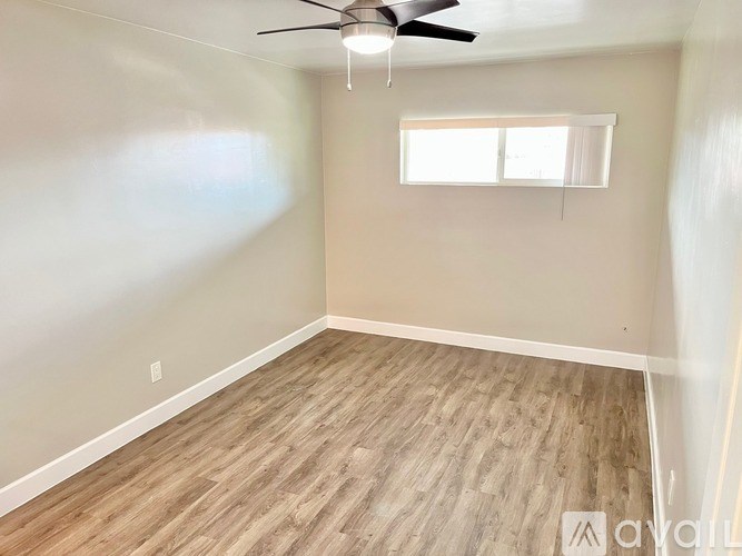 A room with a ceiling fan and a window.