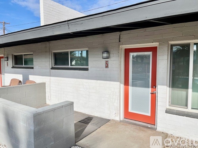 A white building with a red door and windows.