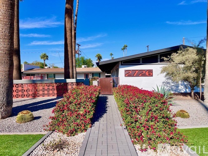 A house numbered 2726 with a red brick wall and a garden in front.